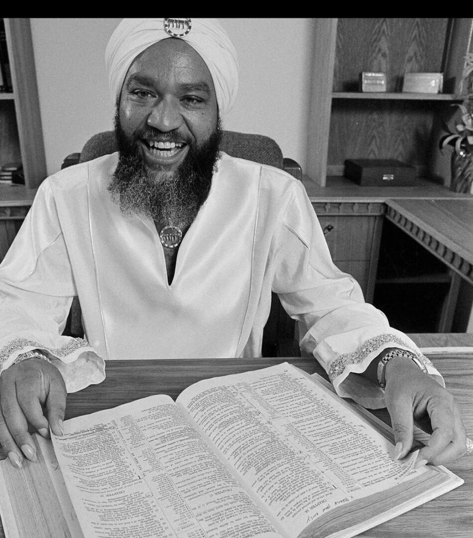 A man in a turban sitting at a desk with an open book, showcasing Ongoing Training.